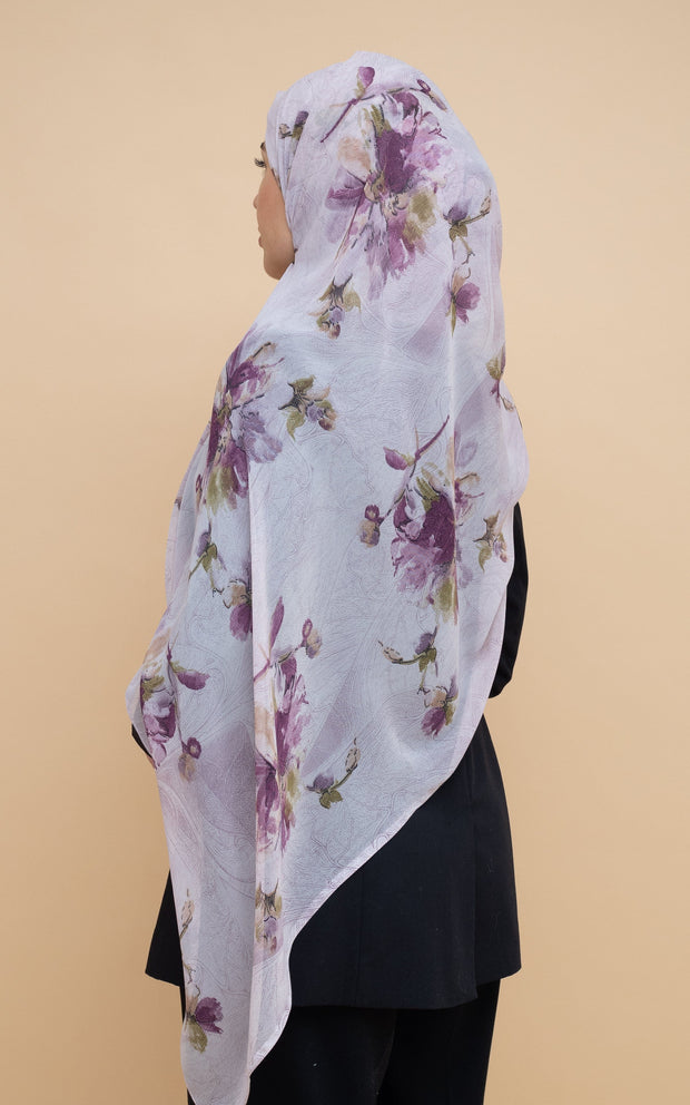 Woman wearing printed chiffon hijab with purple flowers